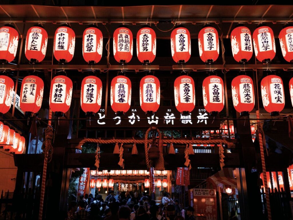 Colorful Japanese lanterns illuminating a bustling street festival at night, evoking the Aomori Nebuta Festival