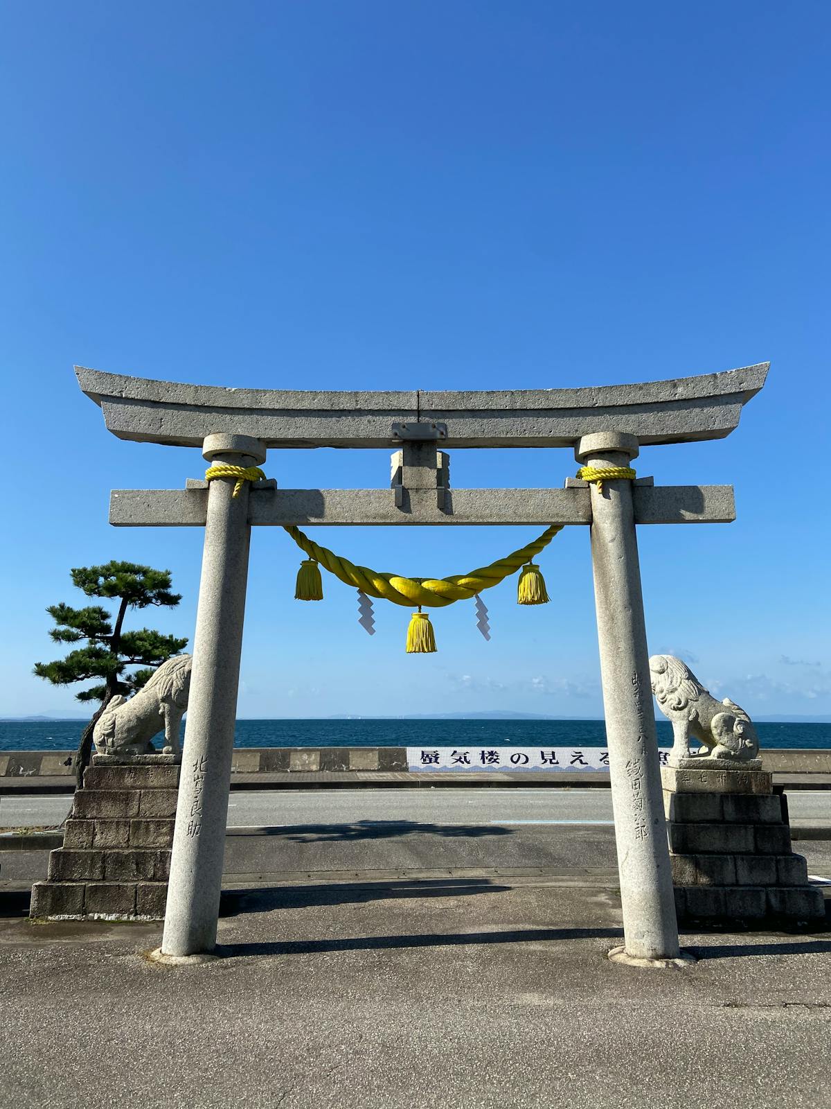 Traditional torii gate at Aoshima Jinja shrine with blue ocean backdrop in Miyazaki Japan