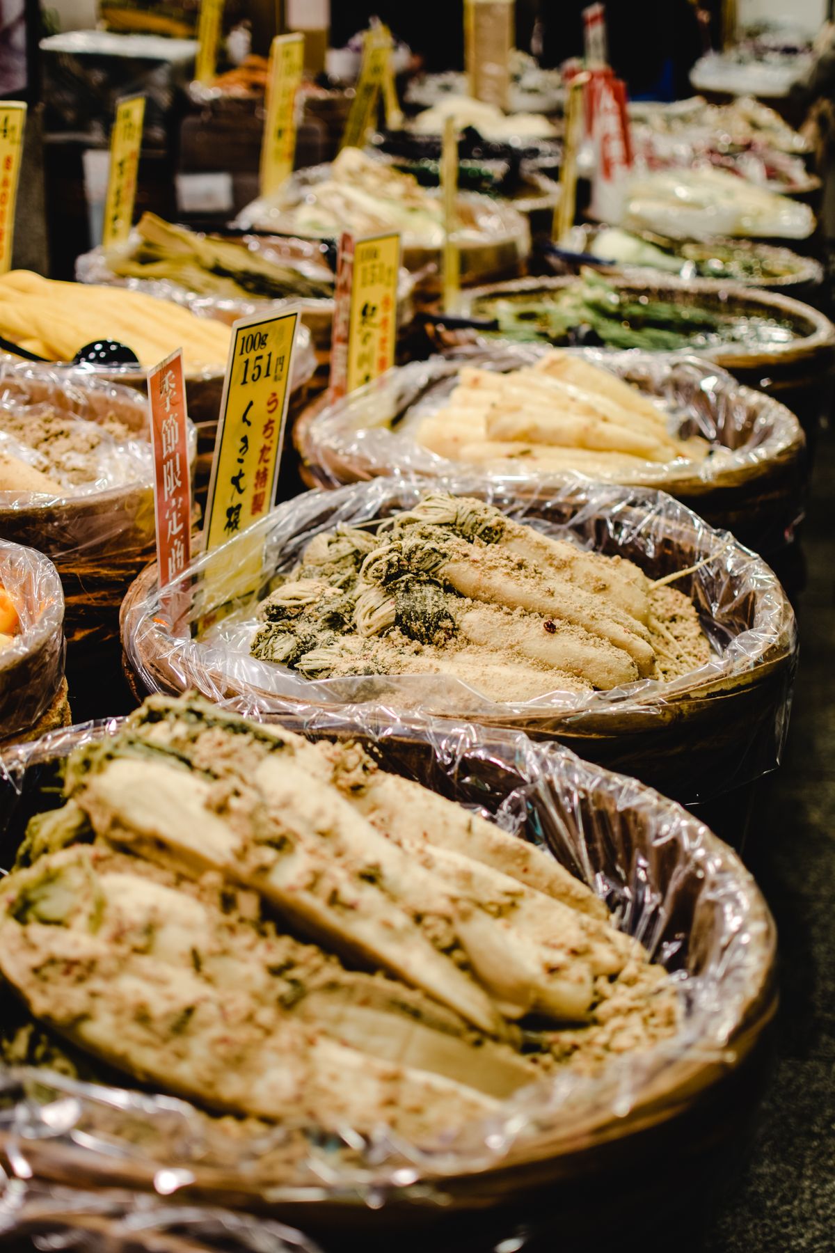 Colorful food stalls selling Japanese pickles and snacks at Nishiki Market in Kyoto, Japan