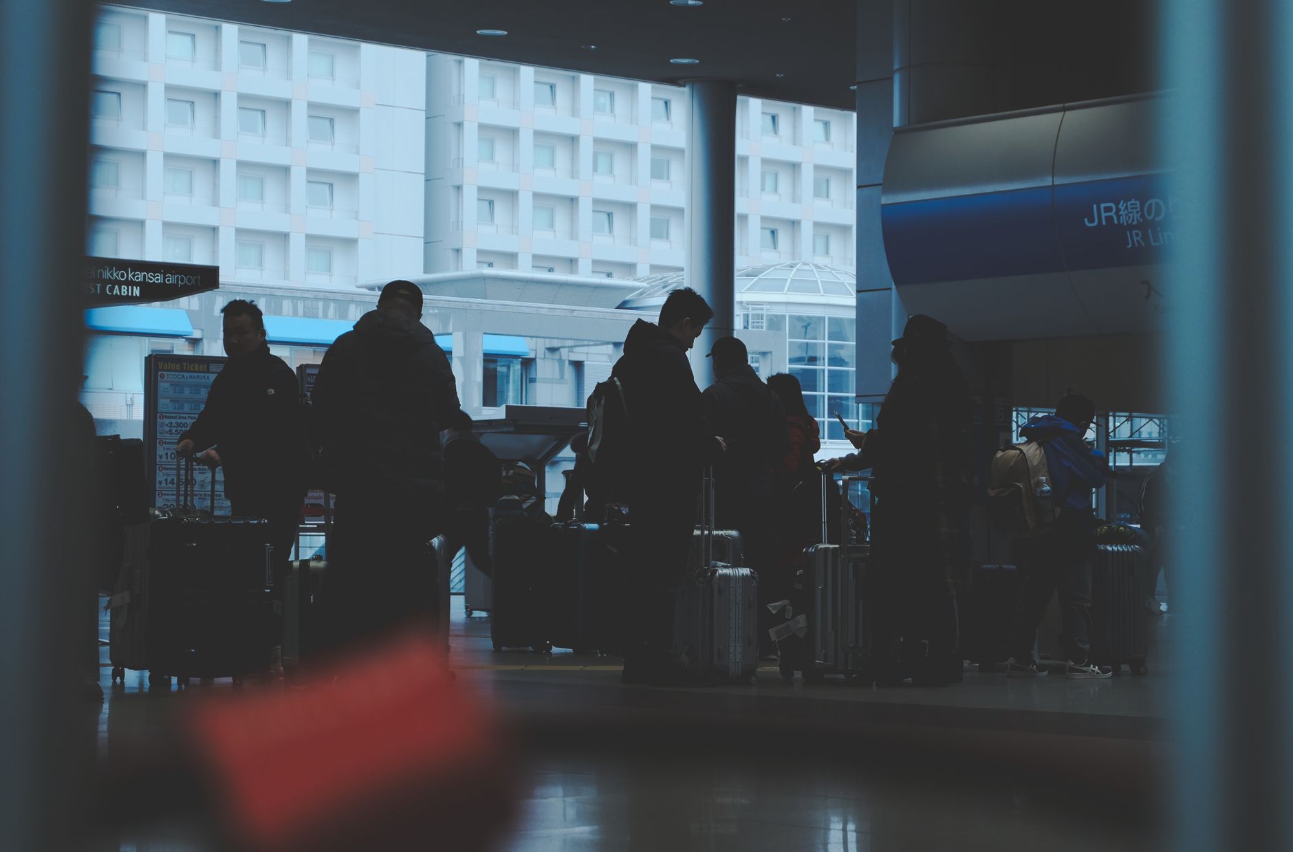 Travelers with luggage at a Tokyo airport terminal