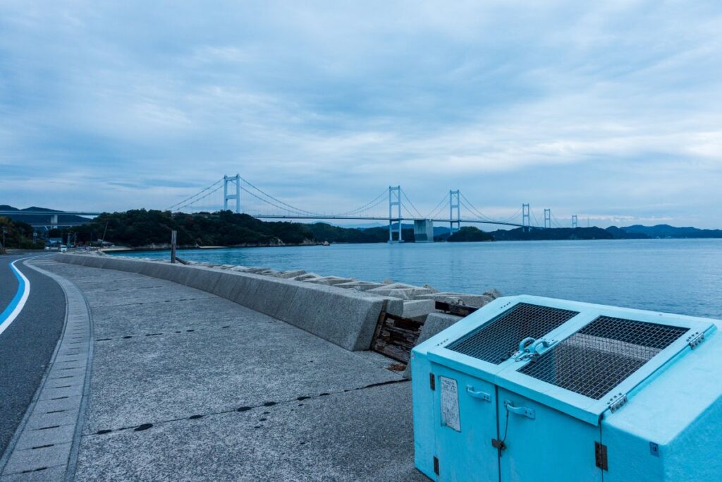View over the Seto Inland Sea near Tomonoura, Hiroshima, with a bridge spanning the calm water between green islands
