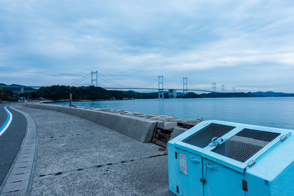 View over the Seto Inland Sea near Tomonoura, Hiroshima, with a bridge spanning the calm water between green islands