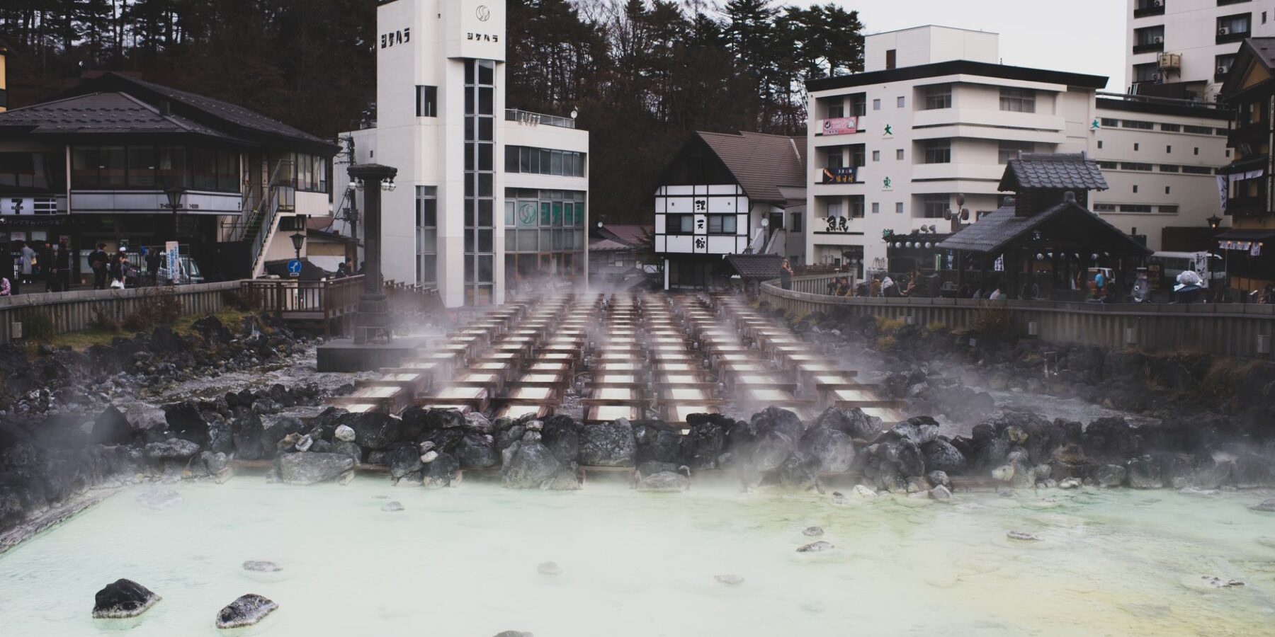 An outdoor Japanese onsen hot-spring bath surrounded by rocks