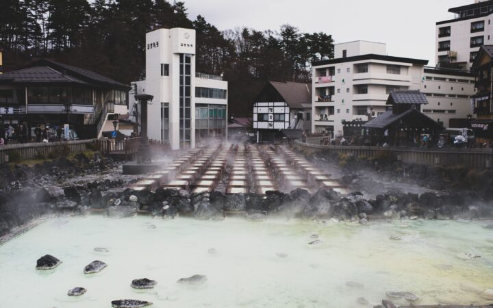 An outdoor Japanese onsen hot-spring bath surrounded by rocks
