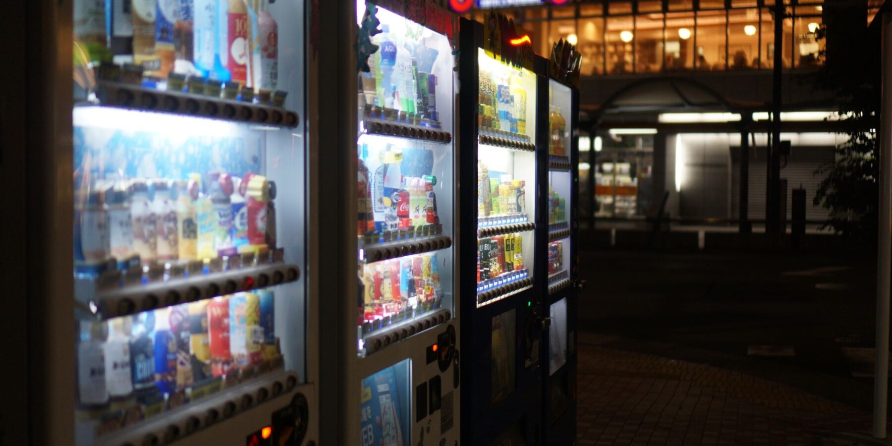 Glowing Japanese vending machines on a street at night