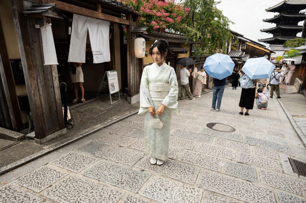 A woman in a rented kimono walking along a narrow traditional street in Kyoto