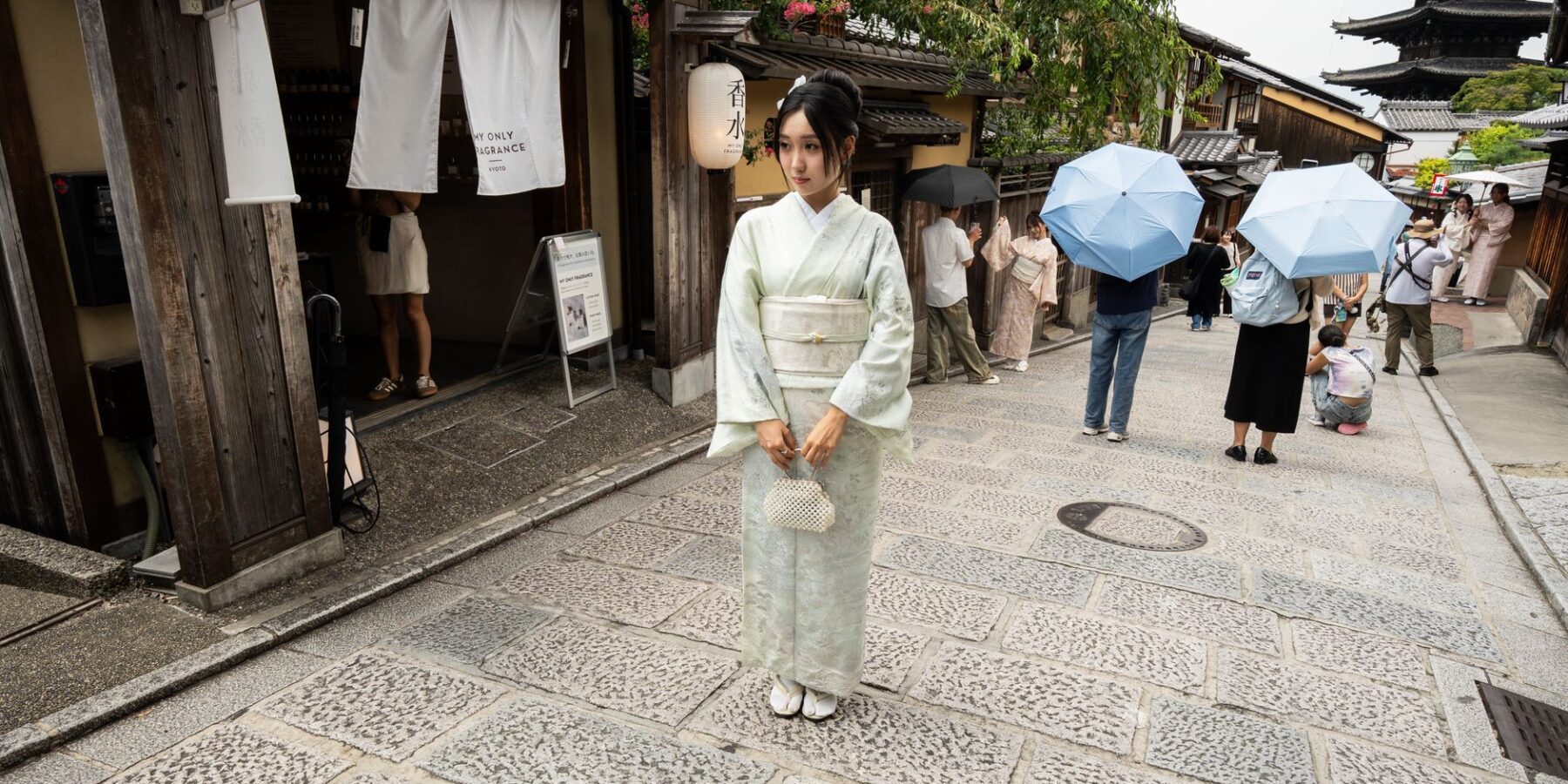 A woman in a rented kimono walking a traditional Kyoto street