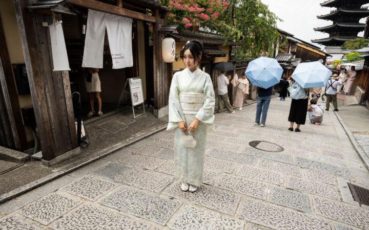 A woman in a rented kimono walking a traditional Kyoto street