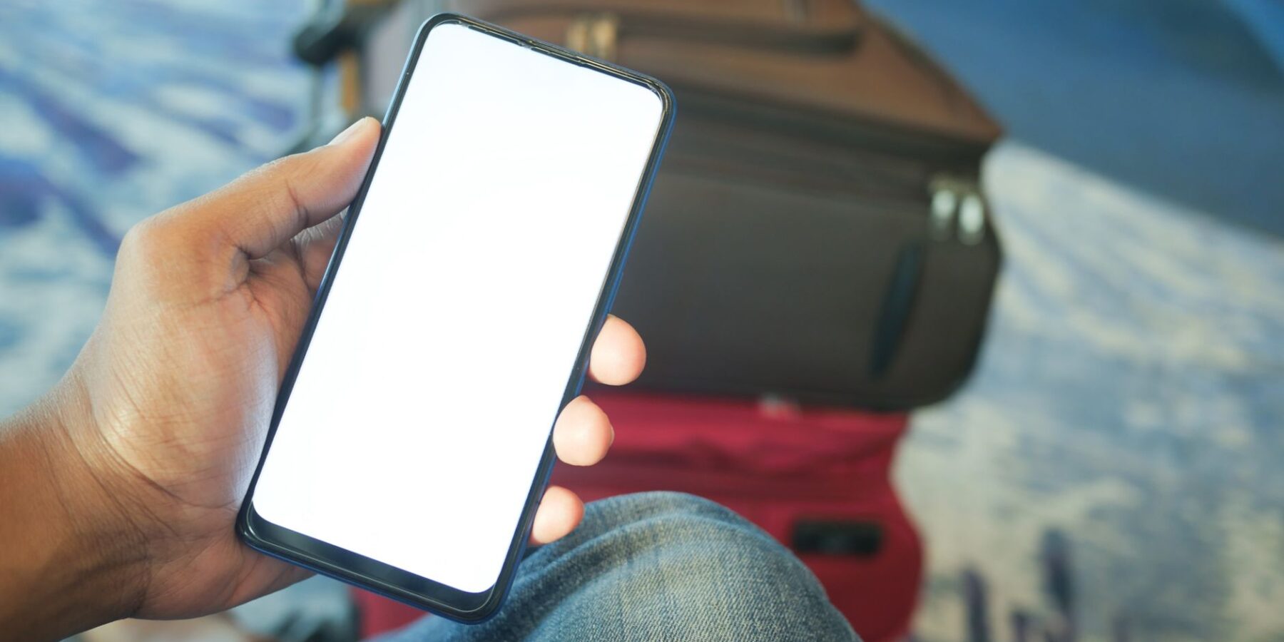 A traveler checking a smartphone at an airport