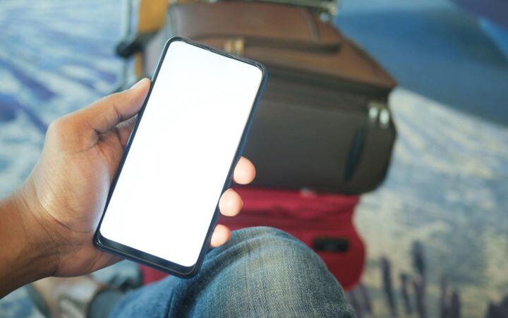 A traveler checking a smartphone at an airport
