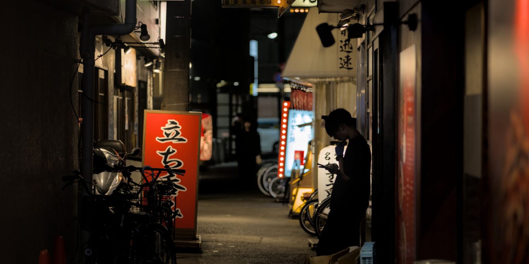 A traveler using a smartphone on a busy Japanese street