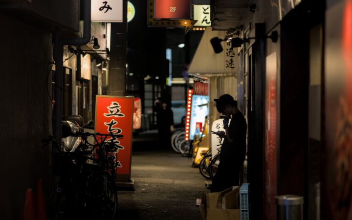 A traveler using a smartphone on a busy Japanese street