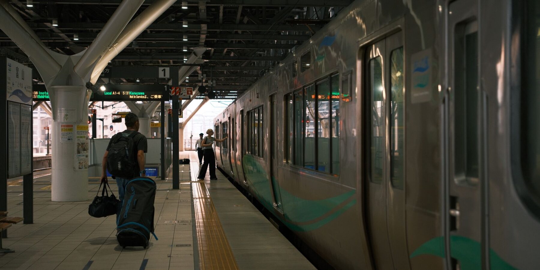A traveler with a suitcase at a Japanese train station