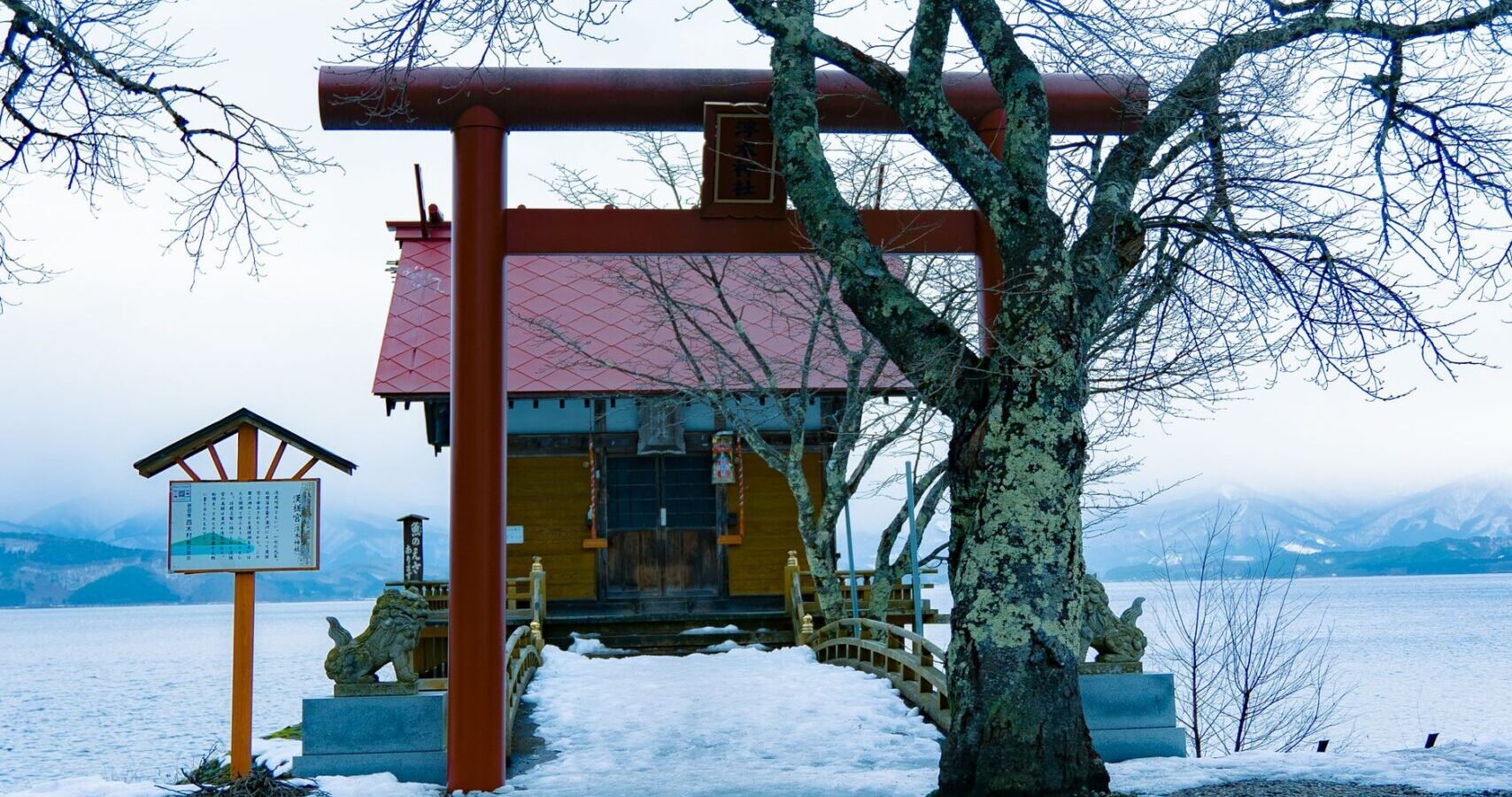 Ukiki Shrine torii on the snowy shore of Lake Tazawa in Akita, Japan