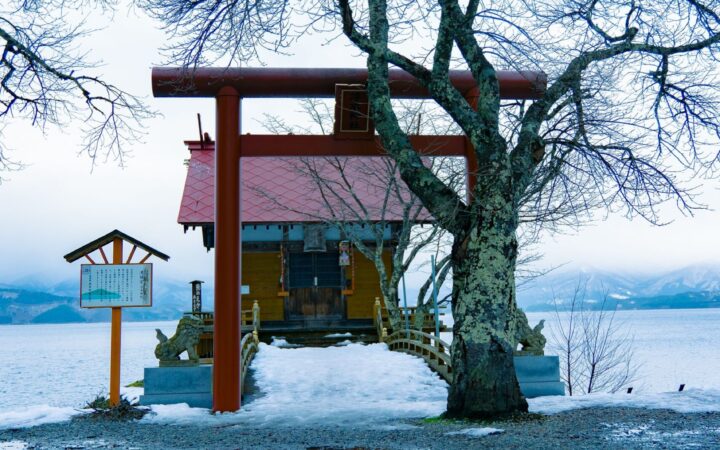 Ukiki Shrine torii on the snowy shore of Lake Tazawa in Akita, Japan