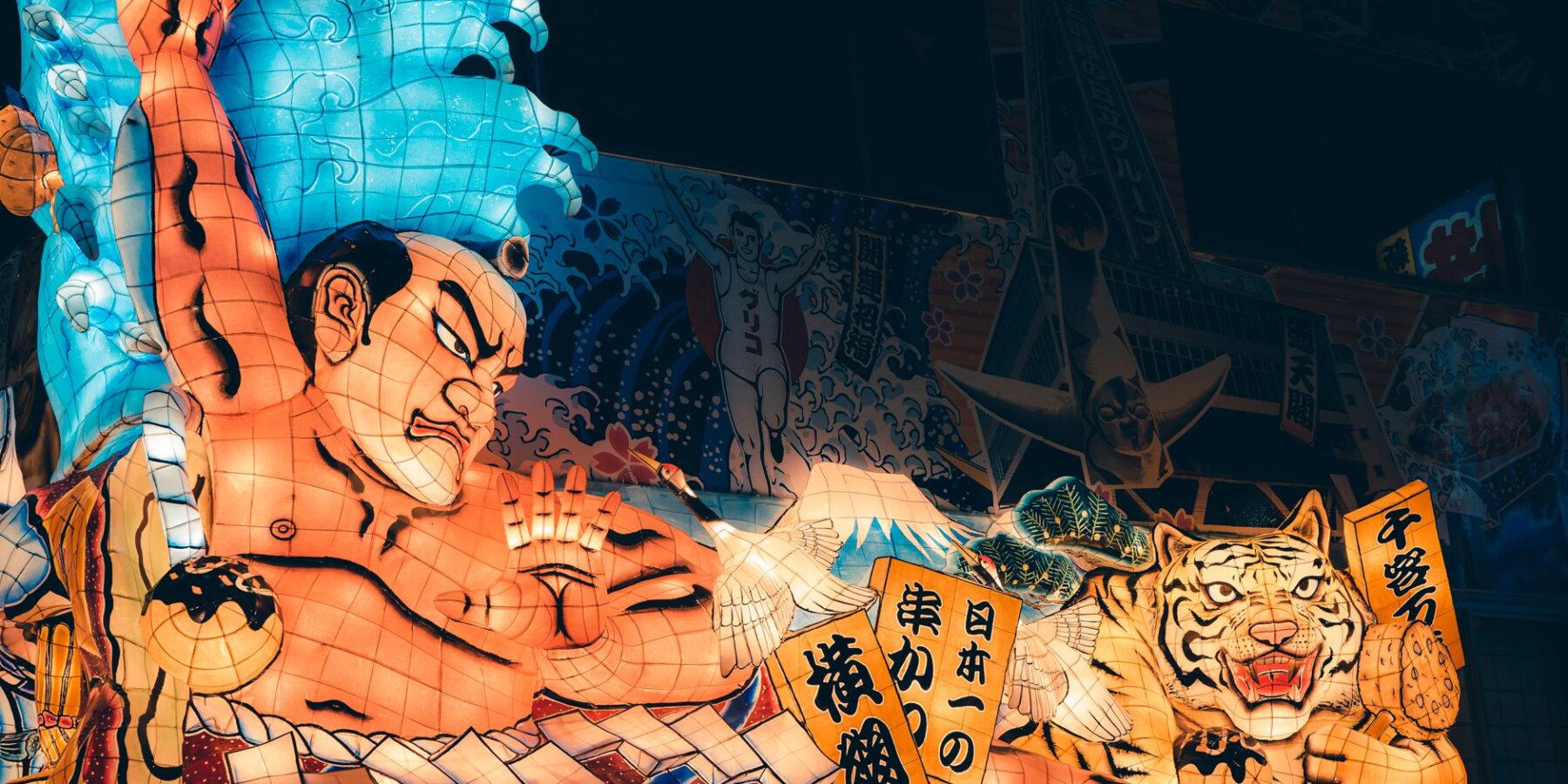 A giant illuminated Nebuta float of a warrior and a tiger at night