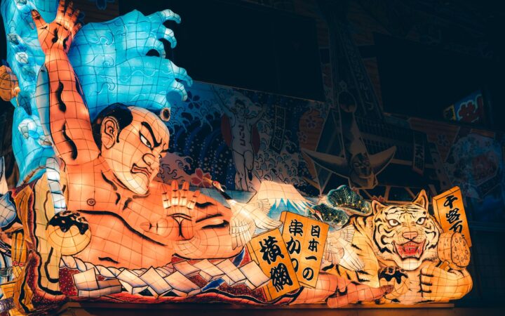 A giant illuminated Nebuta float of a warrior and a tiger at night