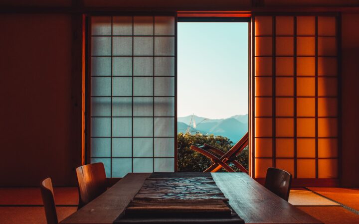 Traditional Japanese inn room with shoji screens opening onto a mountain view