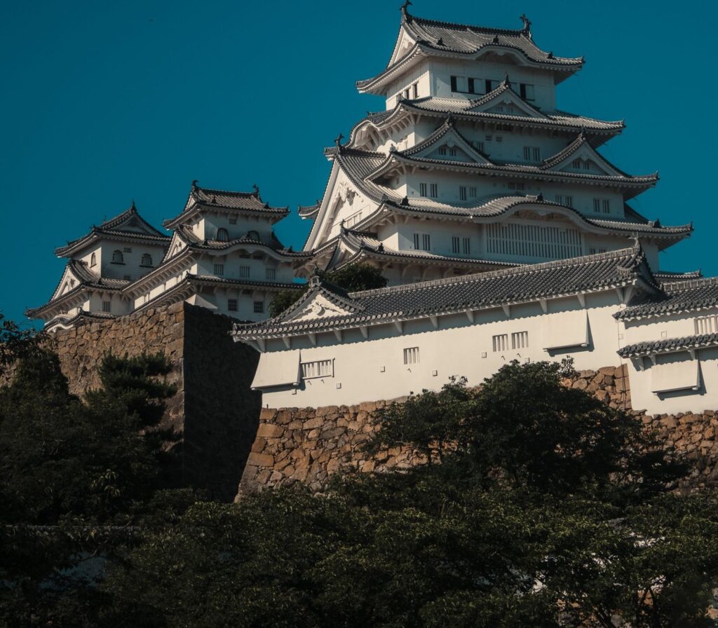 The white keep and turrets of Himeji Castle above its stone walls in Hyogo