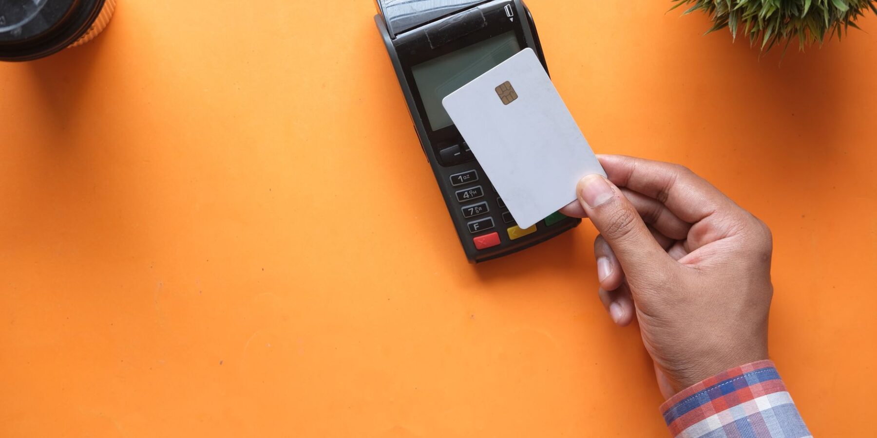 Person paying with a contactless credit card at a card terminal