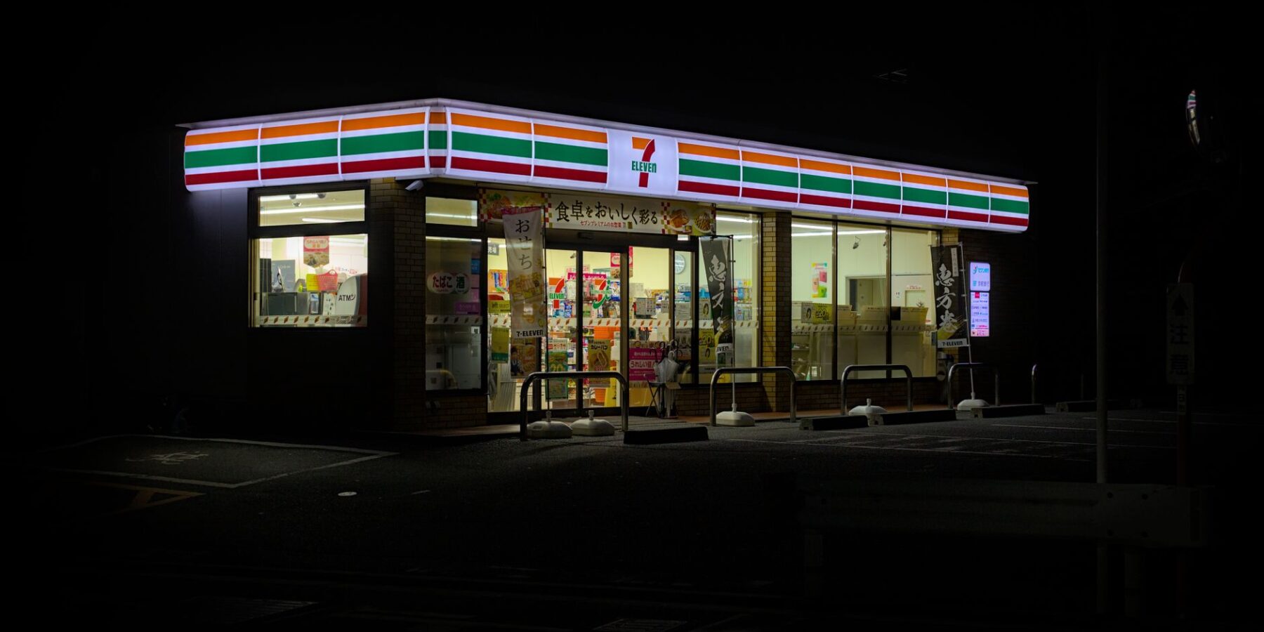 Illuminated 7-Eleven convenience store at night in Kyoto, Japan