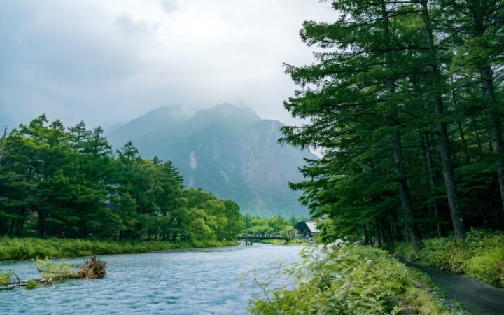 Clear Azusa River and forested mountains in Kamikochi, Nagano