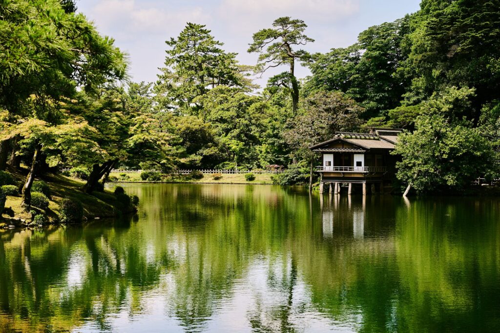 Kenrokuen Garden pond with a teahouse and pine trees in Kanazawa, Ishikawa, Japan