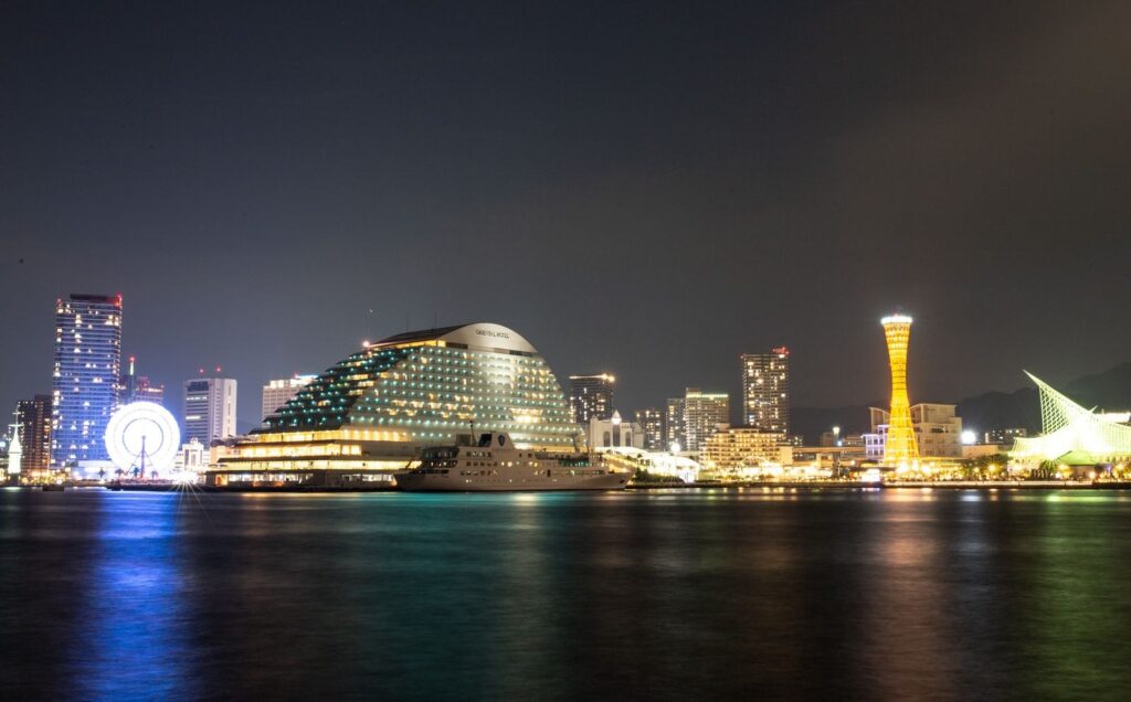 Kobe Harbor at night with the red Kobe Port Tower, a Ferris wheel and waterfront hotels