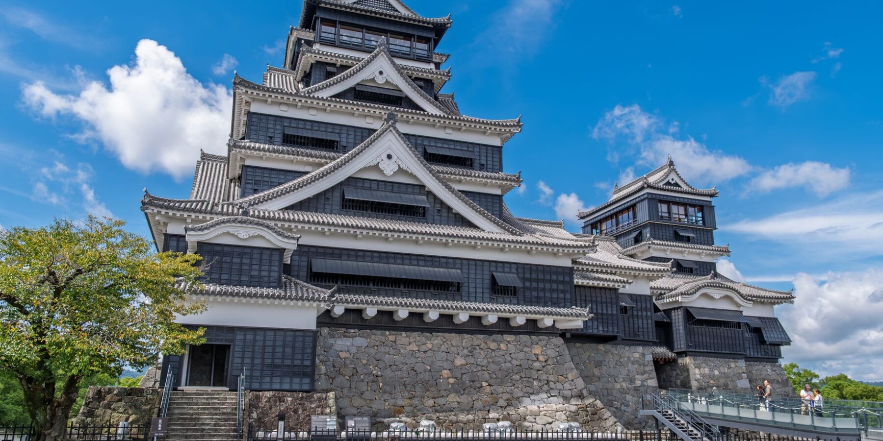 Kumamoto Castle keep and stone walls under a blue sky in Kumamoto, Japan