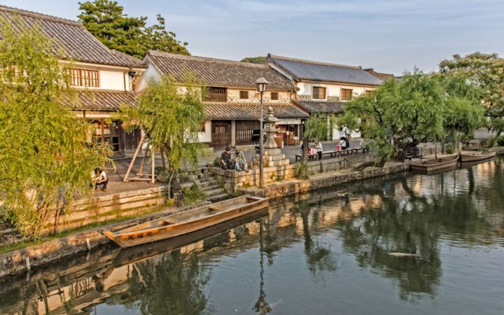 Willow-lined Kurashiki canal with traditional boats and white-walled storehouses, Okayama