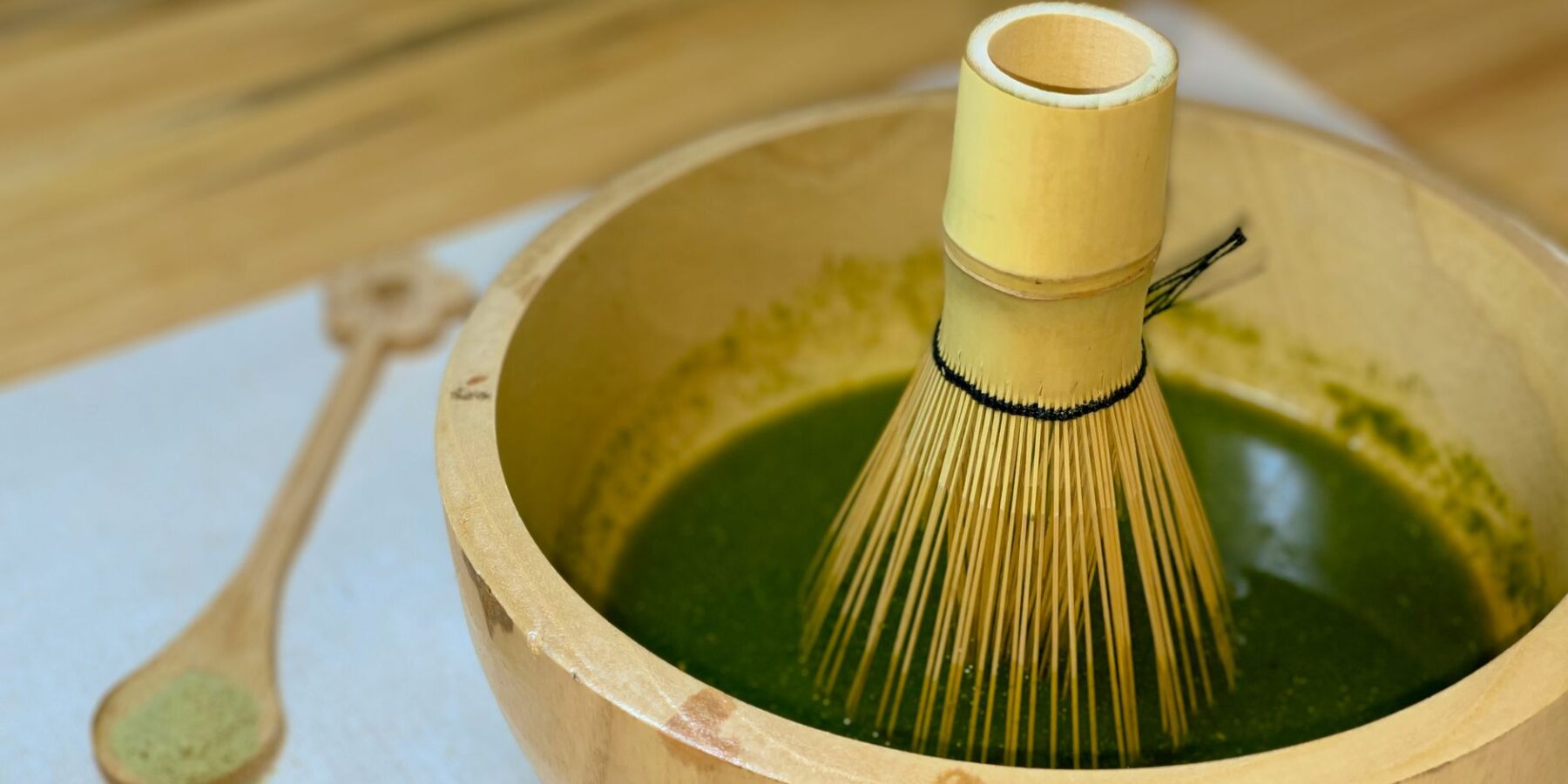 Bamboo whisk in a bowl of freshly whisked matcha green tea