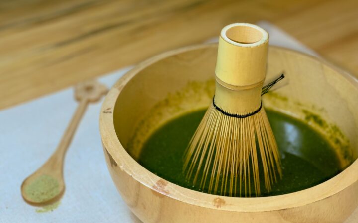 Bamboo whisk in a bowl of freshly whisked matcha green tea