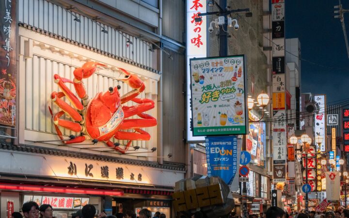 Giant crab sign and neon-lit restaurant street in Dotonbori, Osaka, Japan
