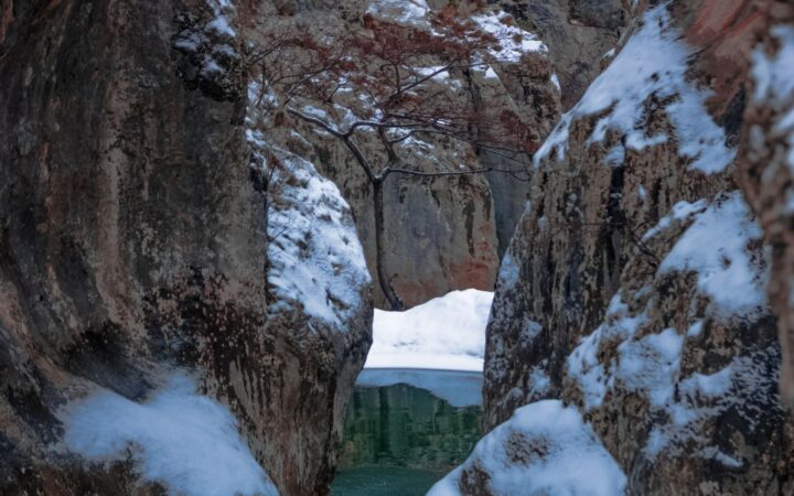Snow-dusted rock walls of a narrow river gorge in Japan