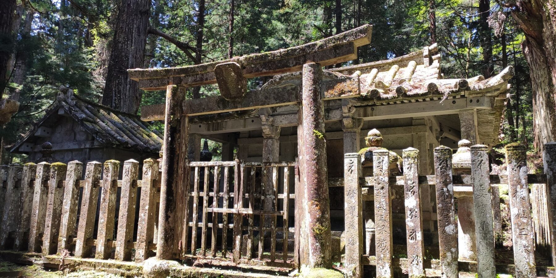 Moss-covered stone gate of an old mausoleum in the Koyasan forest, Wakayama